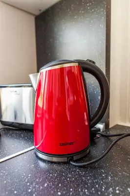 a red toaster sitting on top of a kitchen counter at Templova Old Town Apartment in Prague