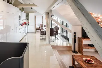 a kitchen and dining room with white walls and wooden floors at Templova Old Town Apartment in Prague