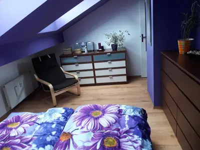 a bedroom with a bed and a chair and a dresser at Sunny Two-story Apartment Kyje in Prague