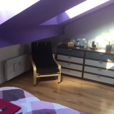 a bedroom with a black chair and a desk at Sunny Two-story Apartment Kyje in Prague