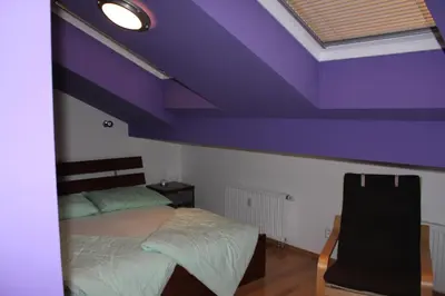 a bedroom with a purple ceiling with a bed at Sunny Two-story Apartment Kyje in Prague