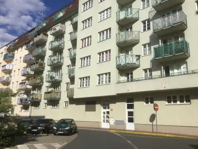a large apartment building with cars parked in front of it at Sunny Two-story Apartment Kyje in Prague