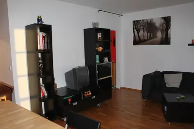 a living room with a couch and a tv at Sunny Two-story Apartment Kyje in Prague