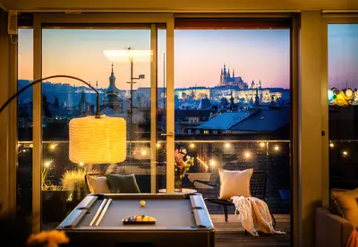 a pool table on a balcony with a view of the castle at Billionaires Boutique Residence & Premium Suites, Old Town in Prague