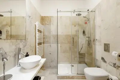 a bathroom with a shower and a toilet and a sink at Limehome Prague Halkova in Prague