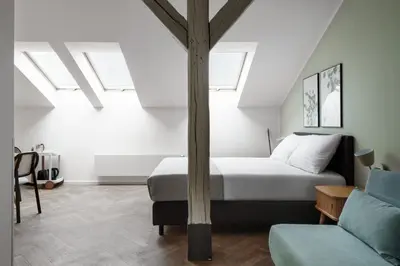a bedroom with a bed and a couch at Limehome Prague Halkova in Prague