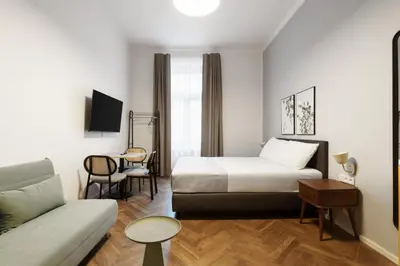 a hotel room with a bed and a couch at Limehome Prague Halkova in Prague