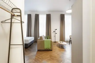 a living room with a couch and a bed at Limehome Prague Halkova in Prague