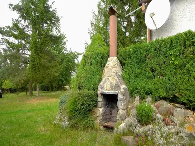 a stone oven in a yard next to a house at Outdoor Adventure & Relaxation in Svinařov
