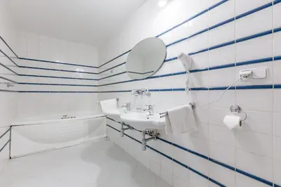 a white bathroom with a sink and a mirror at Hotel U Rytíře in Mělník