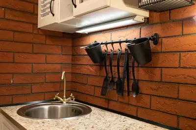 a kitchen with a sink and a brick wall at St. Terezie - Baroque Residence in Prague