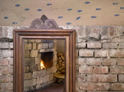 a mirror in a brick wall with a fireplace at Hotel La Romantica in Mladá Boleslav