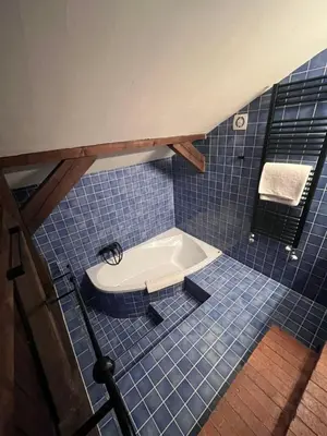 a bathroom with a tub in a blue tiled floor at Hotel La Romantica in Mladá Boleslav