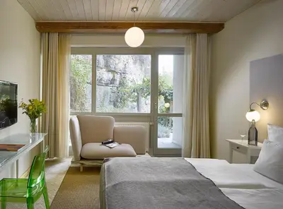 a bedroom with a bed and a chair and a window at Hotel La Romantica in Mladá Boleslav
