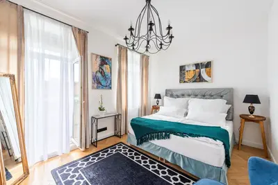 a bedroom with a bed and a chandelier at Luxury apartment with a balcony and a terrace in Prague