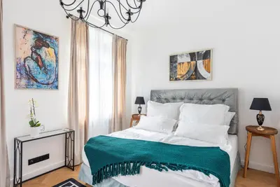 a bedroom with a bed with a green blanket on it at Luxury apartment with a balcony and a terrace in Prague