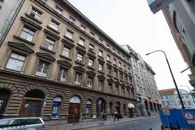 a large building on a street with people walking in front of it at Luxury apartment with a balcony and a terrace in Prague