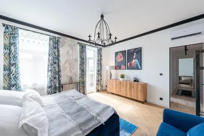 a bedroom with a large bed and a blue chair at Luxury apartment with a balcony and a terrace in Prague