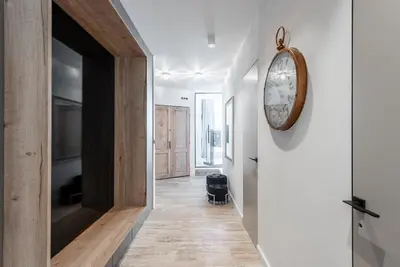 a hallway with a clock on the wall at Luxury apartment with a balcony and a terrace in Prague