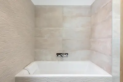 a white bath tub in a bathroom with a sink at Luxury apartment with a balcony and a terrace in Prague