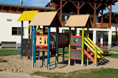 a playground with colorful play equipment in the sand at Sportovní areál Horní Počaply in Horní Počaply