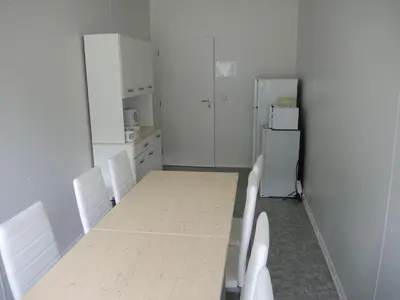 a kitchen with a table and chairs and a refrigerator at Sportovní areál Horní Počaply in Horní Počaply