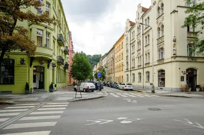 a city street with cars parked on the sides of buildings at Apartment Gesse Březinova in Prague