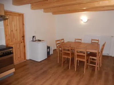 a dining room with a wooden table and chairs at Apartment U Lochů in Kňovičky
