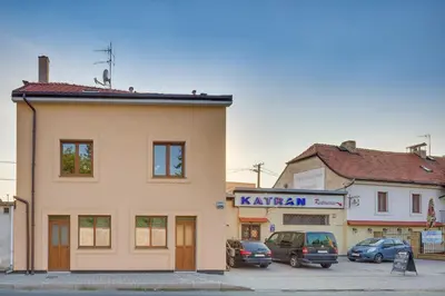 a building with cars parked in a parking lot at Apartements Studio 964 in Líbeznice