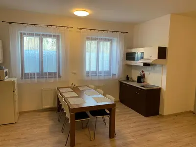 a kitchen with a wooden table and a kitchen with a table and chairs at Apartements Studio 964 in Líbeznice