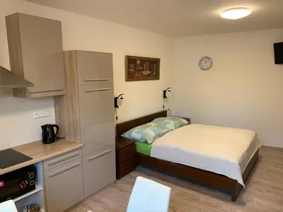 a small bedroom with a bed and a kitchen at Apartements Studio 964 in Líbeznice