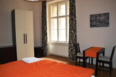 a bedroom with a bed and a desk and a window at Valentina Apartments in Prague