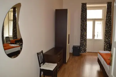 a bedroom with a mirror and a bed and a chair at Valentina Apartments in Prague