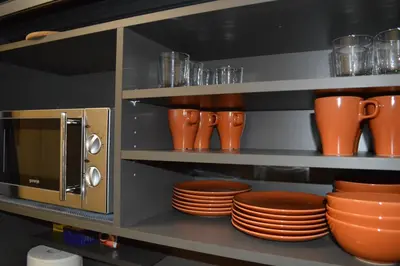 a shelf with plates and cups and utensils at Valentina Apartments in Prague
