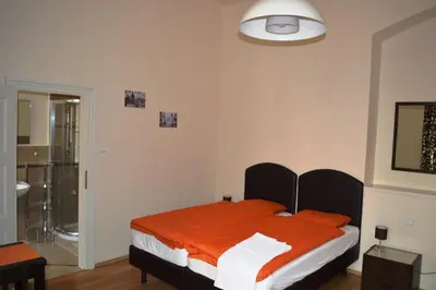 a bedroom with a bed with an orange blanket at Valentina Apartments in Prague