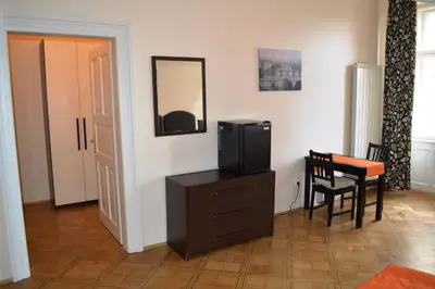 a room with a tv on a dresser with a table and a mirror at Valentina Apartments in Prague