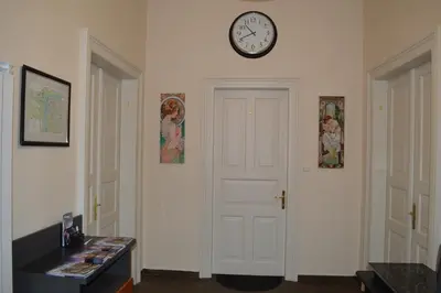 a room with a door and a clock on the wall at Valentina Apartments in Prague