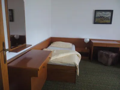 a bedroom with a bed and a desk and a mirror at Hotel BESTAR in Mladá Boleslav