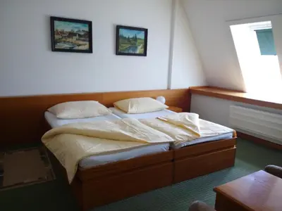 a bedroom with a bed with two pillows and a window at Hotel BESTAR in Mladá Boleslav