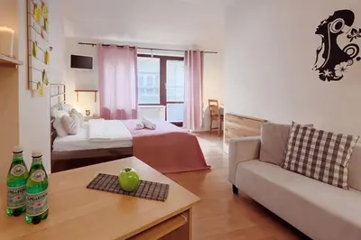 a living room with a bed and a couch at Downtown Apartments Kozatska in Prague