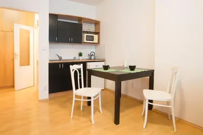 a kitchen with a table and chairs in a room at Downtown Apartments Kozatska in Prague