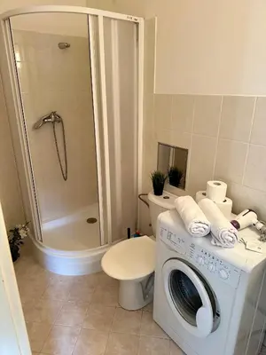 a bathroom with a washing machine and a toilet at Downtown Apartments Kozatska in Prague