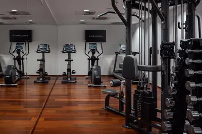 a gym with rows of exercise equipment in a room at COSMOPOLITAN Hotel Prague in Prague