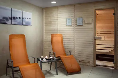 a room with chairs and a table and a sauna at COSMOPOLITAN Hotel Prague in Prague
