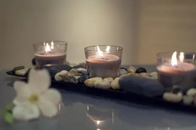 a tray with three candles on a table with rocks at COSMOPOLITAN Hotel Prague in Prague