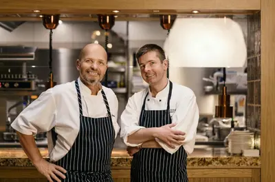 two men are standing in a kitchen at COSMOPOLITAN Hotel Prague in Prague