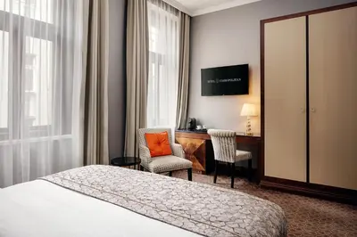 a hotel room with a bed and a desk at COSMOPOLITAN Hotel Prague in Prague