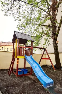 a playground with a slide and a tree at Kasablanka apartments in Prague