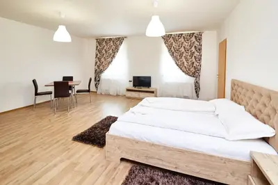 a bedroom with a large bed and a table with chairs at Kasablanka apartments in Prague