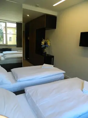 a room with three beds and a mirror at Hotel Bílý Páv in Benátky nad Jizerou